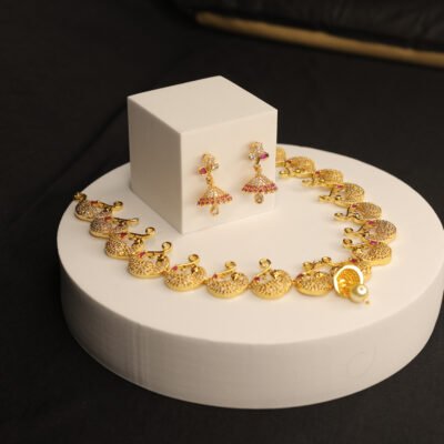 Designer gold-plated necklace set with sparkling stones and matching jhumka earrings.